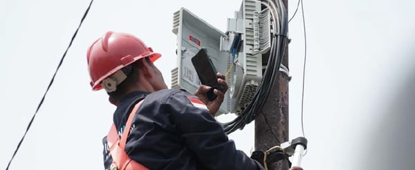 Telecom field engineer taking a picture of equipment on their phone