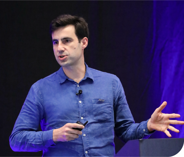 Augustin Marty=, Senior Vice President of AI Solutions at IQGeo on stage presenting 