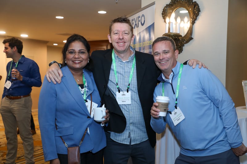 Three delegates at the 2025 IQGeo Americas Meetup smiling at the camera