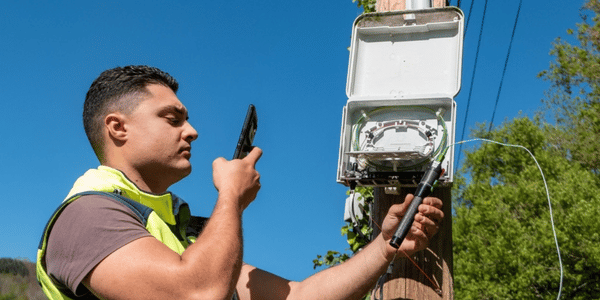 IQGeo-Telecom-Field-Engineer-using-mobile-device-600x300